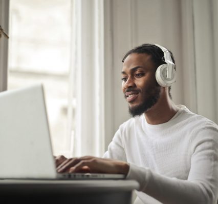 young-man-studies-with-pc-listening-music young-man-studies-with-pc-listening-music