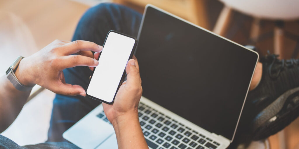 Personne utilisant un iPhone et un MacBook.