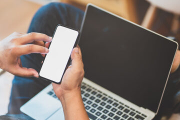 Personne utilisant un iPhone et un MacBook.