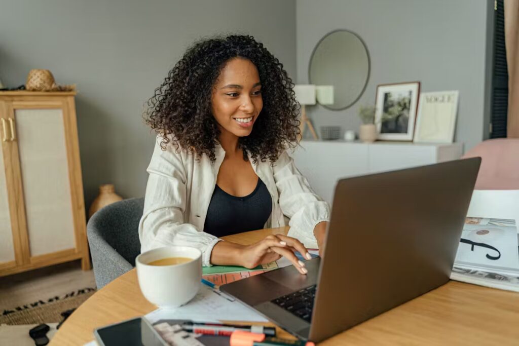 Une femme métisse travaille sur son ordinateur portable.